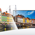 BRAVIA TV with screenshot of boats in a harbour and multicoloured houses behind with continuation of the scene extending out of the TV to the left